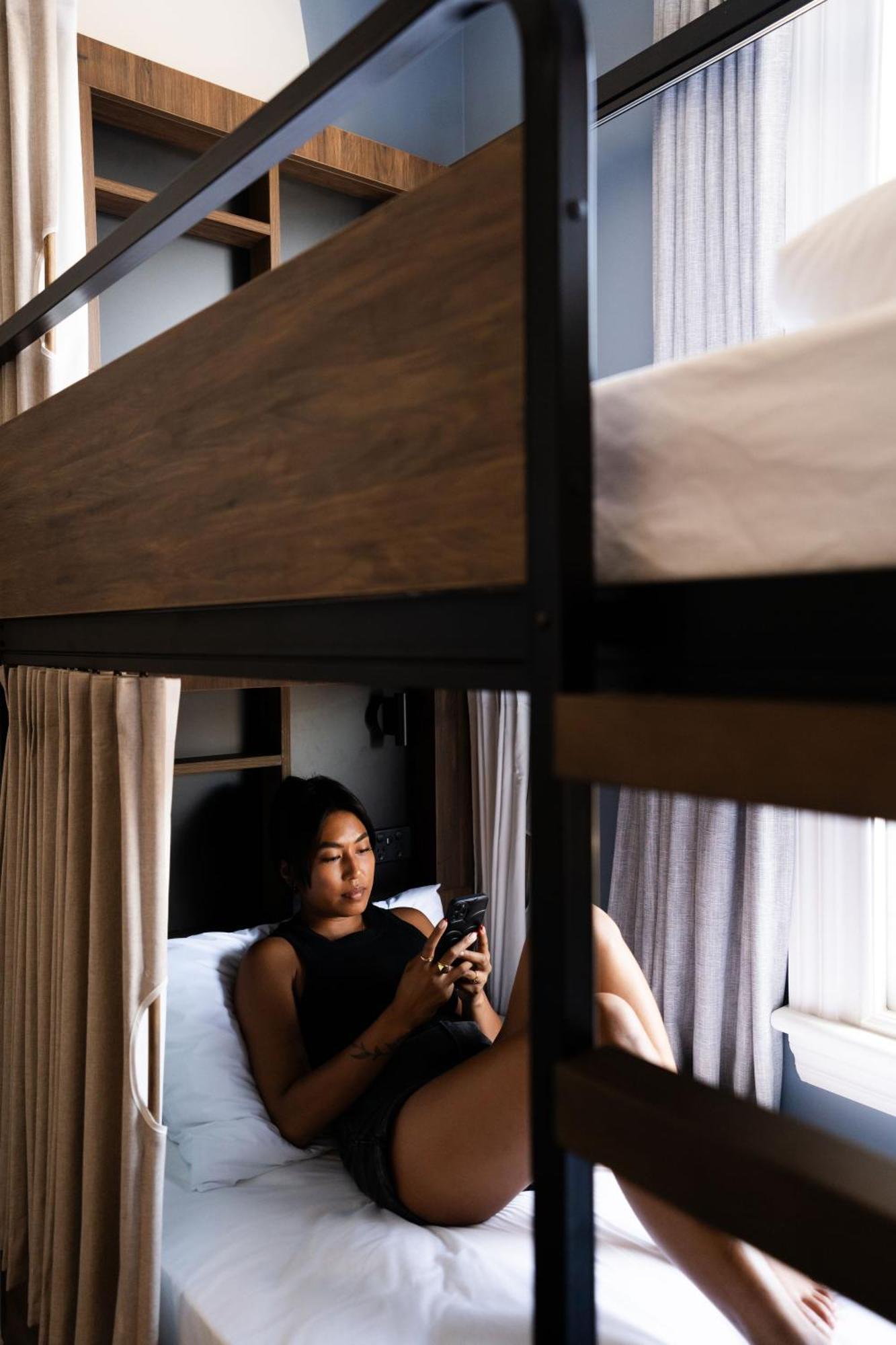 Haka House Christchurch Ngoại thất bức ảnh A woman using a mobile phone in a hostel